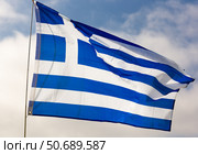 Against background of cloudy sky,white-blue flag of Greece flutters on flagpole. Стоковое фото, фотограф Яков Филимонов / Фотобанк Лори