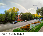 Газоны и клумбы на фоне радуги и зеленых деревьев в городе. Москва, Башиловская улица после дождя (2024 год). Редакционное фото, фотограф Ирина Терентьева / Фотобанк Лори
