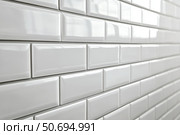 Ceramic tiles with a glossy finish and beveled edges set into horizontal brickwork. The sleek and clean wall design is ideal for kitchens and bathrooms with a minimalist or modern aesthetic. Banner. Стоковое AI-изображение, AI-художник Евгений Демидюк / Фотобанк Лори