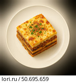 Мусака Классическая греческая запеканка из слоёных баклажанов, мясного фарша и соуса бешамель, поданная порционным квадратом. Стоковое AI-изображение, AI-художник Владислав Войтов / Фотобанк Лори