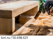 The process of burning wooden boards with a burner. The texture of wood treated with fire from a burner. Close-up. Стоковое фото, фотограф Photojuli / Фотобанк Лори