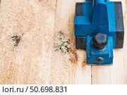 A hand-held electric planer in the hands of a craftsman. A man planing boards with an electric tool. Production of wooden products. Construction, wood processing. Стоковое фото, фотограф Photojuli / Фотобанк Лори