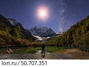 The Milky Way and waxing cresent moon over Mount Chenrezig in China (2016 год). Стоковое фото, фотограф Jeff Dai/Stocktrek Images / ТАСС / Фотобанк Лори