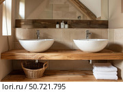 Modern bathroom interior showing two sinks and wooden countertop. Стоковое AI-изображение, AI-художник Иван Рябоконь / Фотобанк Лори