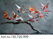 Origami cranes perched on a branch, symbol of peace and hope. Стоковое AI-изображение, AI-художник Иван Рябоконь / Фотобанк Лори