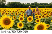 A family poses in a field of sunflowers. Стоковое AI-изображение, AI-художник Ярославский Максим / Фотобанк Лори
