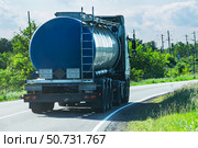 A fuel truck with a blue tanker drives along a country asphalt road. Стоковое фото, фотограф Антон Вахрушев / Фотобанк Лори