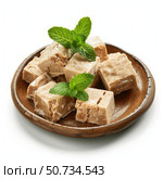 Delicious creamy nougat with mint leaves on wooden plate. Стоковое AI-изображение, AI-художник Иван Рябоконь / Фотобанк Лори