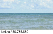 Sunny beach with a turquoise ocean in the background. Sea waves near the tropical coast on a sunny day. Cruise. Landscape of a summer sea beach with white sand and shells. Travel concept footage. Стоковое видео, видеограф Ирина Михайличенко / Фотобанк Лори