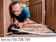 Plumber installs compression fitting to reconnect two sections of burst multilayer pipe damaged by frozen water during cold winter conditions. Стоковое фото, фотограф Владимир Григорьев / Фотобанк Лори