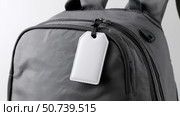 Stylish gray backpack showcased with a blank tag for personalization. Стоковое AI-изображение, AI-художник Katsiaryna Repich / Фотобанк Лори