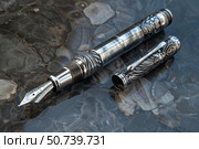 Elegant engraved fountain pen resting on marble surface. Стоковое AI-изображение, AI-художник Иван Рябоконь / Фотобанк Лори