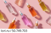 Colorful glass bottles of skincare serums arranged on a pink background. Стоковое AI-изображение, AI-художник Сергей Толмачёв / Фотобанк Лори