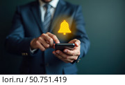 Push-уведомление. Бизнесмен держит смартфон с виртуальным жёлтым звонком. Стоковое AI-изображение, AI-художник Илья Старков / Фотобанк Лори