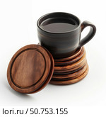 Dark ceramic mug resting on stack of wooden coasters. Стоковое AI-изображение, AI-художник Иван Рябоконь / Фотобанк Лори