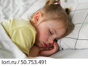 Peaceful adorable baby sleeping on a bed at home. Slumbering little child. Two years old girl sleeps peaceful at domestic room interior background. Serene dream. Cute face close up. Deep kid slumber. Стоковое фото, фотограф Марина Демидюк / Фотобанк Лори