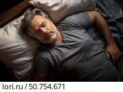 Mature man sleeping peacefully in bed, enjoying restful night. Стоковое AI-изображение, AI-художник Иван Рябоконь / Фотобанк Лори