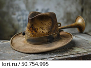 Rusty fedora hat with antique brass horn. Стоковое AI-изображение, AI-художник Иван Рябоконь / Фотобанк Лори