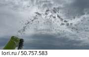 Slow motion where white foam flies out onto the playground to celebrate. Foam cannon on the background of the sky with clouds. Стоковое видео, видеограф Darya Komarova / Фотобанк Лори