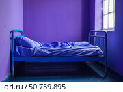 Empty bed in purple room with metal frame and unmade sheets. Стоковое AI-изображение, AI-художник Иван Рябоконь / Фотобанк Лори