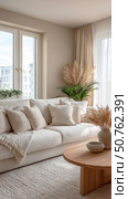 Bright neutral-toned living room with cozy white sofa, wooden coffee table, decorative pillows, and pampas grass, styled in a modern boho minimalist aesthetic. Стоковое AI-изображение, AI-художник Катерина Бондарец / Фотобанк Лори