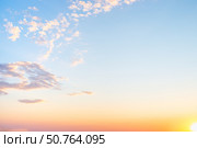 Sunrise with light cirrus clouds in soft orange and pink tones, with the sun on the horizon. Стоковое фото, фотограф Коханова Наталья / Фотобанк Лори
