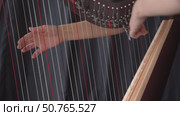 A close up of the hands of a female harpist playing harp solo during a performance. Стоковое видео, видеограф Darya Komarova / Фотобанк Лори