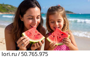 Mom and daughter are eating a watermelon on a tropical beach. Стоковое AI-изображение, AI-художник Ирина Гильмуллина / Фотобанк Лори