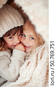 Two Adorable Little Girls Huddled Together Under a Cozy Blanket. Стоковое AI-изображение, AI-художник Данила Большаков / Фотобанк Лори