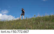 Man is running a beautiful scenic hill covered in vibrant, blooming wildflowers. Male walking on a hillside among bright clear blue sky. A man strolls through a grassy field, outdoor atmosphere. Стоковое видео, видеограф Марина Демидюк / Фотобанк Лори