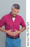 Mature man suffering from abdominal pain on white background. Стоковое AI-видео, аниматор Юрий Поздников / Фотобанк Лори