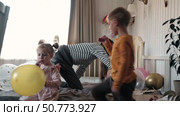 Fun Kids Celebration with Colorful Balloons, Party Horn Blowers and Festive Hats. Joyful Siblings Children Playful Little Girls and a Boy Dancing, Jumping, Playing among Golden Decorations. Party Time. Стоковое видео, видеограф Марина Демидюк / Фотобанк Лори