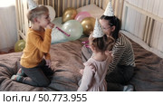 Fun Kids Celebration with Colorful Balloons, Party Horn Blowers and Festive Hats. Joyful Siblings Children Playful Little Girls and a Boy Dancing, Jumping, Playing among Golden Decorations. Party Time. Стоковое видео, видеограф Марина Демидюк / Фотобанк Лори
