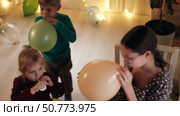 Fun Kids Celebration. Kids inflating balloons, Party Horn Blowers and Festive Hats. Joyful Siblings Children Playful Little Girls and Boy Dancing, Jumping, Playing among Golden Decorations. Party Time. Стоковое видео, видеограф Марина Демидюк / Фотобанк Лори