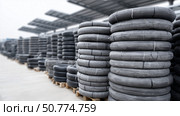 Rubber tires stored in a warehouse, showcasing organized stacking efficiency. Стоковое AI-изображение, AI-художник Katsiaryna Repich / Фотобанк Лори