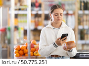 Female buyer scans QR code on cheese label in grocery store. Стоковое фото, фотограф Яков Филимонов / Фотобанк Лори