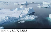 Frozen icebergs floating in calm Arctic waters on sunny day. Стоковое AI-видео, аниматор Андрей Бажанов / Фотобанк Лори