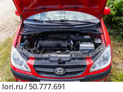 Maykop, Russia - June 27, 2024: The open hood of the Hyundai Getz car is red. Редакционное фото, фотограф Андрей С / Фотобанк Лори