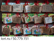 Kyoto, Japan, October 27, 2024: Wooden Ema tablets on which believers write prayers or wishes at the Kiyomizu-dera Buddhist Temple. Редакционное фото, фотограф Ula Ulachka / Фотобанк Лори