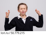 A teenage boy, a high school student, crossed his fingers so that he would not be called to the school board. Стоковое фото, фотограф Лазаренко Светлана / Фотобанк Лори