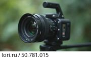 A Camera is Positioned on a Tripod Amidst Greenery, Highlighting Its Lens and Features. Стоковое AI-видео, аниматор Sergey Grishin / Фотобанк Лори