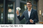 A Happy Man in a Suit Stands Outside a Sleek Building, Proudly Displaying His Cash. Стоковое AI-видео, аниматор Sergey Grishin / Фотобанк Лори