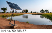 Water pumps and solar panels. Groundwater is pumped with a submersible pump from clean energy or solar energy converted to electric energy on an agricultural farm. Стоковое AI-изображение, AI-художник ALLA YURTAYEVA / Фотобанк Лори