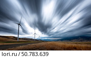 Dark shelf cloud preceding a severe thunderstorm at a wind turbine park. Beautiful thunderstorm black clouds and clouds hanging over the ground. Стоковое AI-изображение, AI-художник ALLA YURTAYEVA / Фотобанк Лори