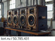 Powerful handmade sound system with wooden case and big loudspeakers is standing in workshop. Стоковое AI-изображение, AI-художник Иван Рябоконь / Фотобанк Лори