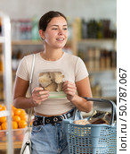 Young woman holding plastic containers with oyster mushrooms, choose mushrooms. Стоковое фото, фотограф Яков Филимонов / Фотобанк Лори