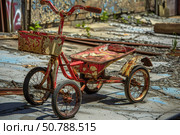 Rusty red tricycle sitting in abandoned building. Стоковое AI-изображение, AI-художник Иван Рябоконь / Фотобанк Лори