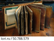 Open vintage briefcase displaying filing system on wooden table. Стоковое AI-изображение, AI-художник Иван Рябоконь / Фотобанк Лори