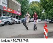 Подростки на электросамокатах в центре г. Ессентуки летом. Редакционное фото, фотограф Лариса Веселова / Фотобанк Лори