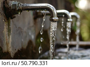 Water pouring from outdoor faucets, creating refreshing streams. Стоковое AI-изображение, AI-художник Иван Рябоконь / Фотобанк Лори